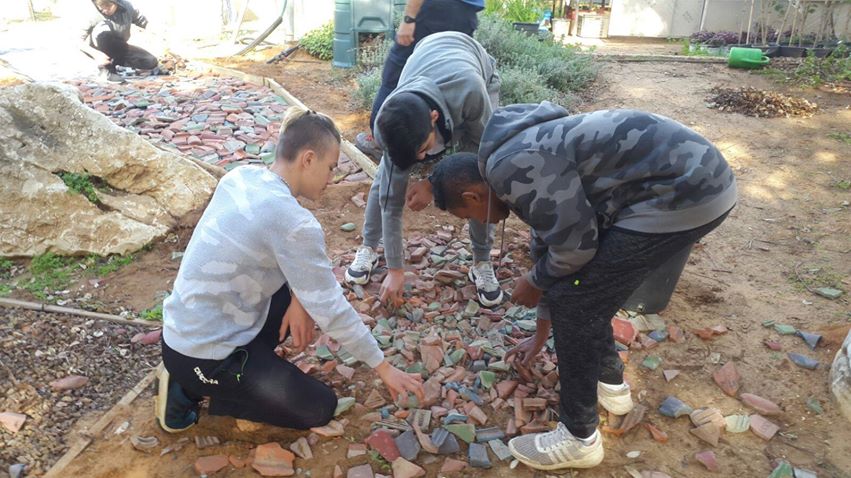 Image may contain: one or more people, people sitting, shoes and outdoor